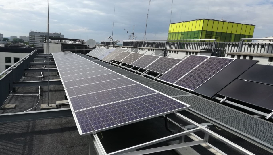 Zdjęcie przedstawia panele słoneczne na dachu budynku przemysłowego.